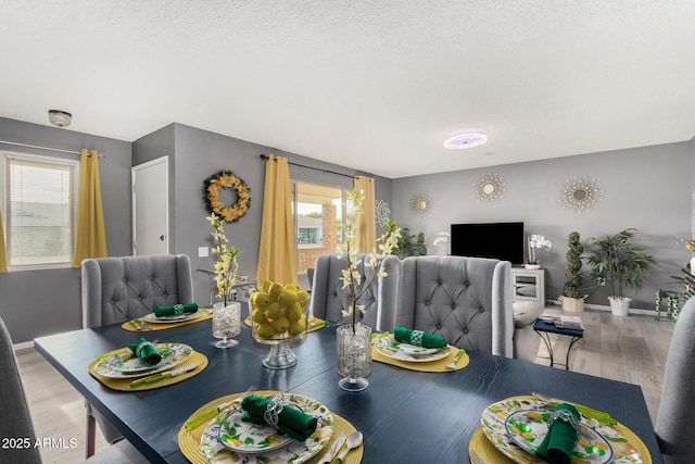 dining area featuring light hardwood / wood-style flooring and a textured ceiling