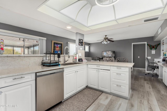 kitchen with sink, light hardwood / wood-style flooring, dishwasher, white cabinetry, and kitchen peninsula