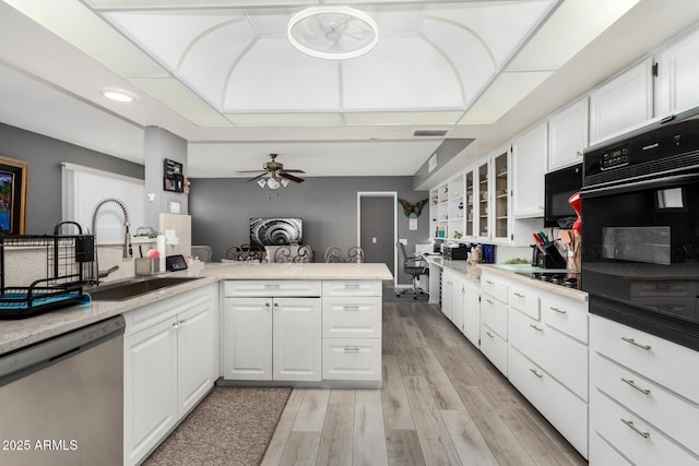 kitchen with white cabinetry, sink, kitchen peninsula, and black appliances