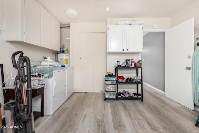 laundry area featuring cabinets, separate washer and dryer, light hardwood / wood-style floors, and water heater