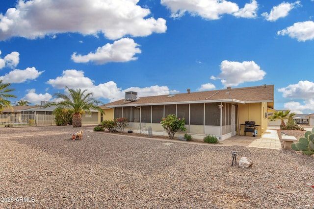 rear view of property featuring a patio area, a sunroom, and central air condition unit