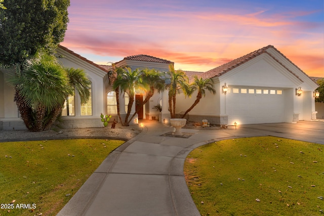 mediterranean / spanish-style house with a garage and a yard