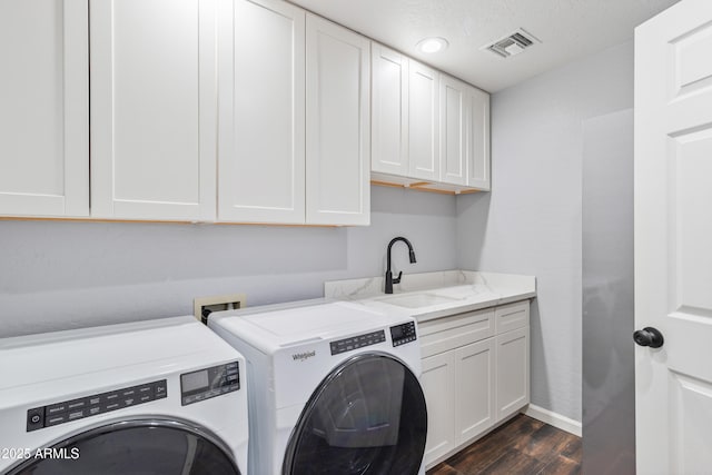 washroom featuring sink, cabinets, separate washer and dryer, a textured ceiling, and dark hardwood / wood-style floors