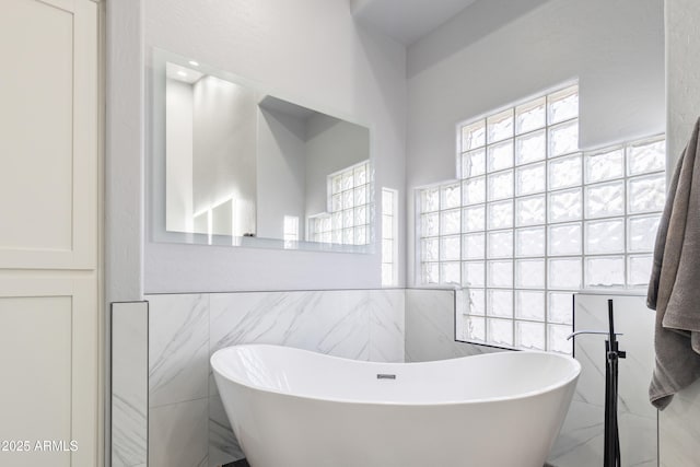 bathroom featuring a tub and tile walls