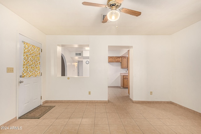 tiled empty room featuring ceiling fan