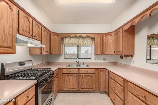 kitchen featuring stainless steel gas range, light tile patterned floors, and sink