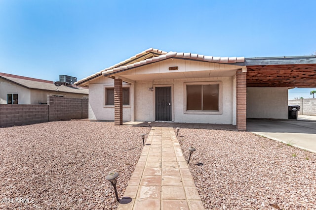 single story home with central AC unit and a carport