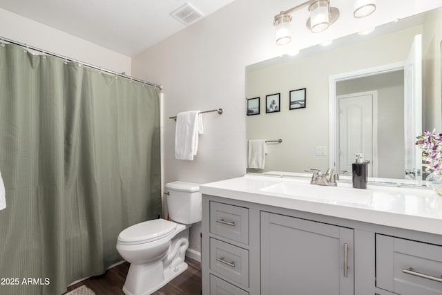 full bathroom featuring wood finished floors, toilet, visible vents, and vanity