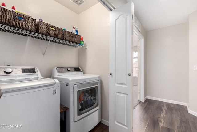 laundry area with visible vents, dark wood-style floors, baseboards, washer and clothes dryer, and laundry area