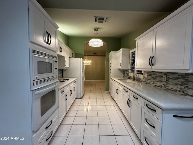 kitchen featuring a notable chandelier, white appliances, white cabinetry, and sink