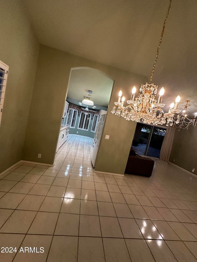 corridor featuring an inviting chandelier, high vaulted ceiling, and tile patterned floors