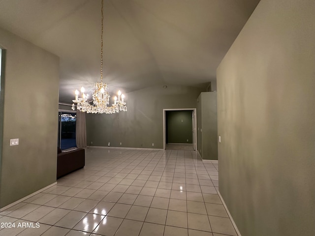 tiled empty room with a notable chandelier and lofted ceiling