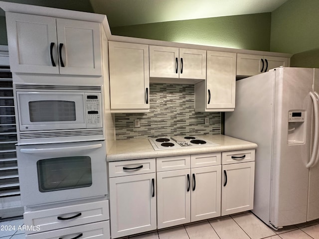 kitchen featuring white cabinets, backsplash, light tile patterned floors, and white appliances