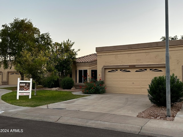 view of front facade with a garage and a lawn