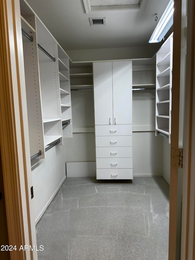 walk in closet featuring light colored carpet