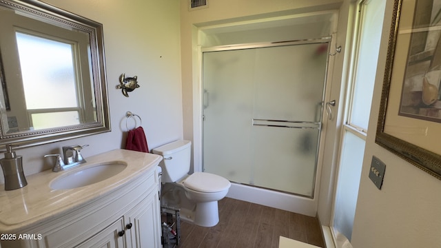 full bath with a shower stall, vanity, toilet, and wood finished floors