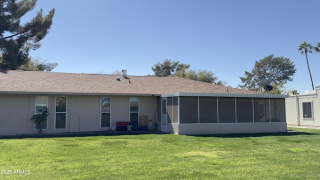 back of house with a lawn, a sunroom, and roof with shingles