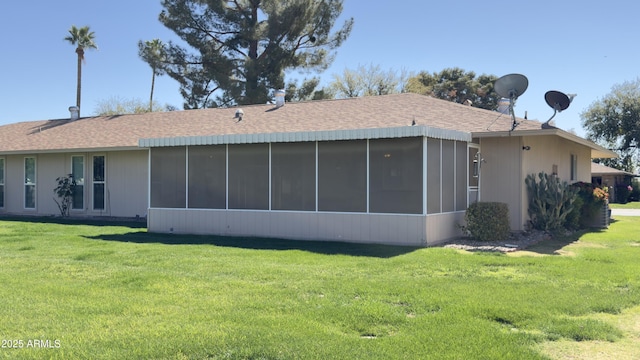 back of property featuring a lawn, roof with shingles, and a sunroom