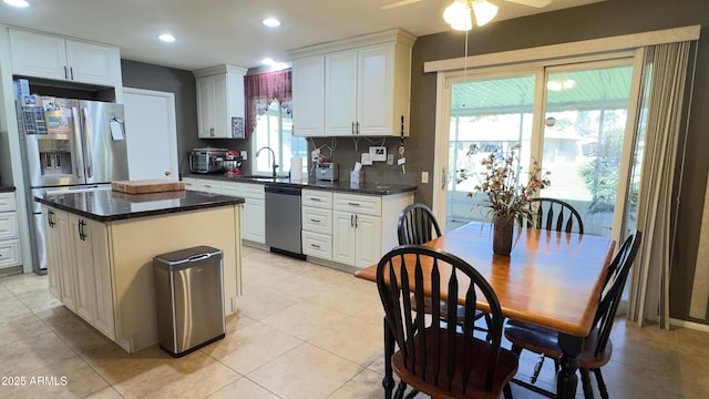 kitchen featuring a sink, stainless steel appliances, ceiling fan, and white cabinetry