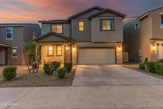 traditional-style home with a garage, covered porch, concrete driveway, and stucco siding