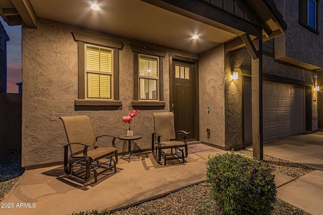 view of exterior entry with a patio area and stucco siding