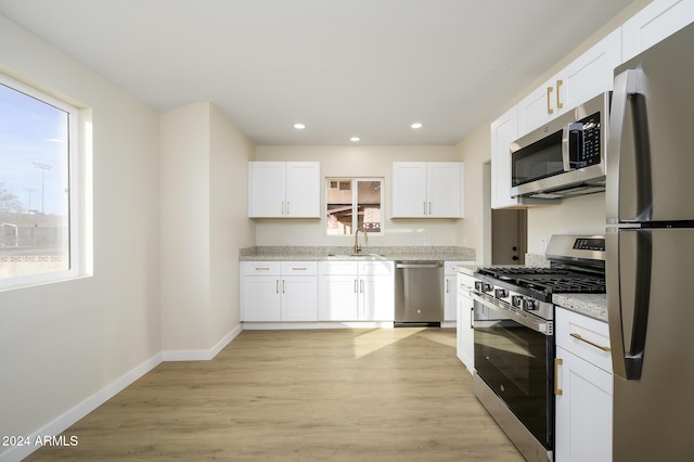 kitchen featuring plenty of natural light, white cabinetry, and stainless steel appliances