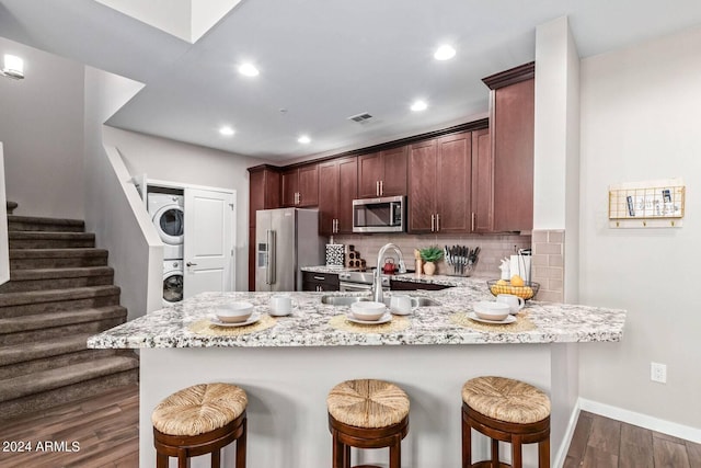 2511 W Queen Creek Rd Unit 425, Chandler, AZ 85248 - kitchen featuring visible vents, a peninsula, stainless steel appliances, a sink, and stacked washer and dryer