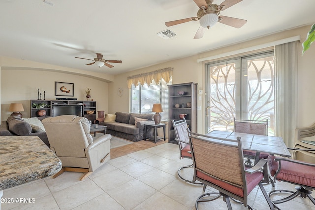 living area featuring light tile patterned floors, ceiling fan, and visible vents