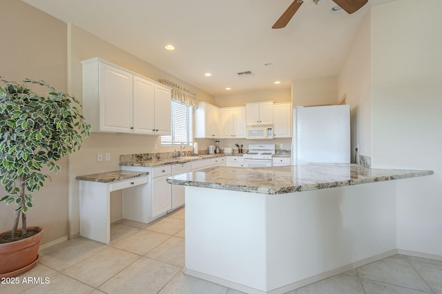 kitchen featuring visible vents, a sink, light stone countertops, white appliances, and a peninsula