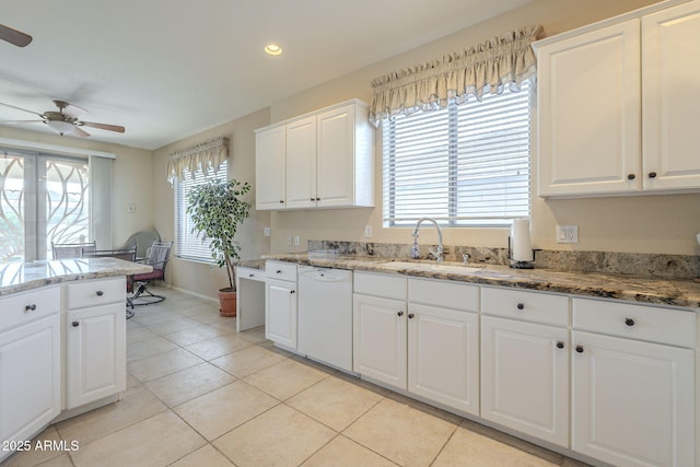 kitchen featuring white cabinets, light tile patterned flooring, white dishwasher, and a sink