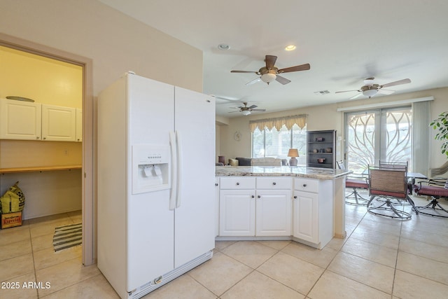 kitchen featuring visible vents, light tile patterned flooring, white cabinetry, white fridge with ice dispenser, and a peninsula