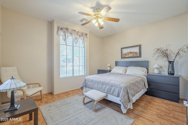 bedroom featuring light wood-style floors, visible vents, ceiling fan, and baseboards