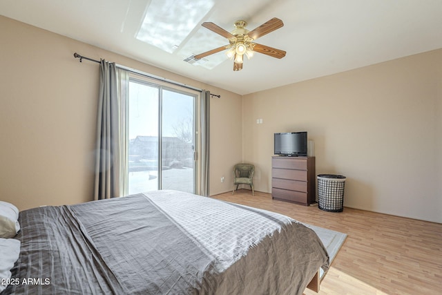 bedroom with light wood-style floors, access to exterior, and a ceiling fan