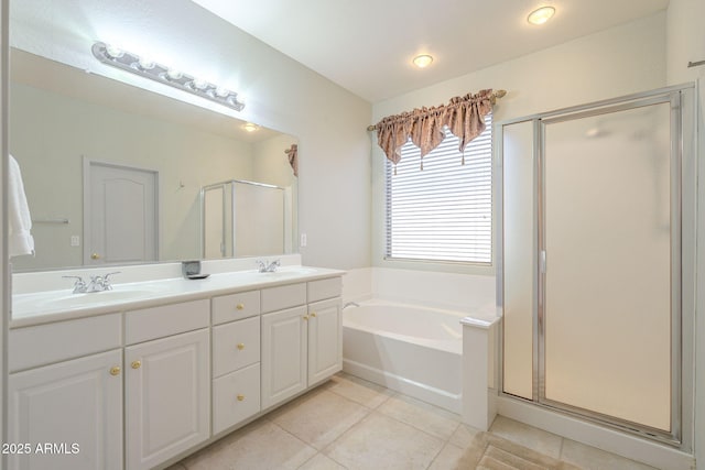 bathroom with a garden tub, double vanity, a stall shower, a sink, and tile patterned flooring