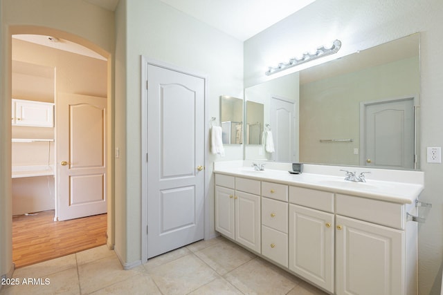 bathroom featuring tile patterned flooring, a sink, and double vanity