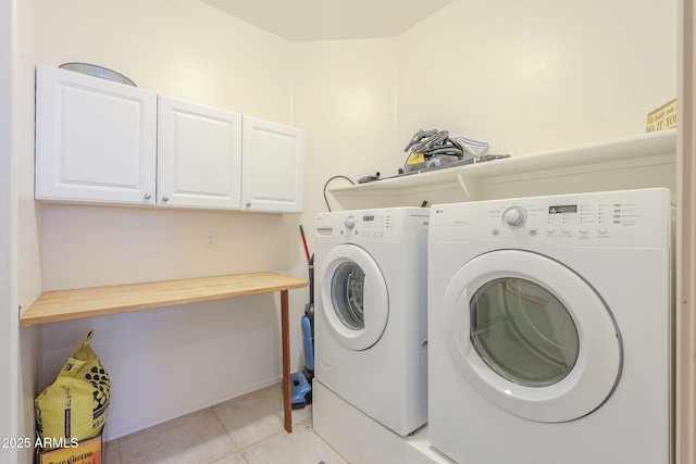 laundry area featuring washing machine and dryer, cabinet space, and light tile patterned floors