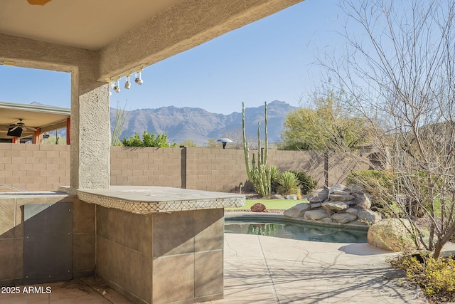 view of patio featuring a fenced in pool, a fenced backyard, and a mountain view