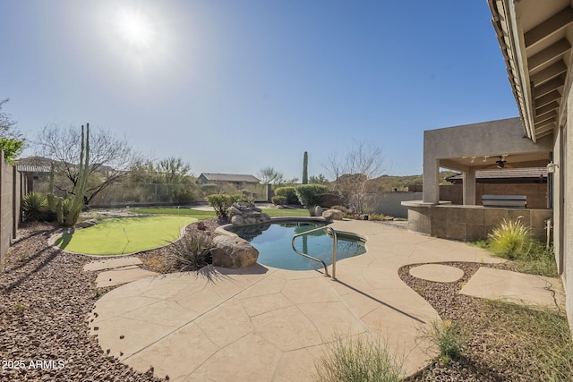 outdoor pool featuring exterior kitchen, a patio area, a fenced backyard, and a ceiling fan