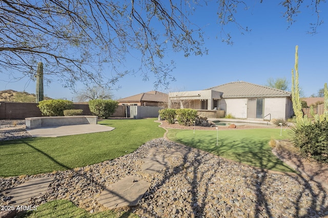 rear view of property with a patio area, a yard, a fenced backyard, and stucco siding