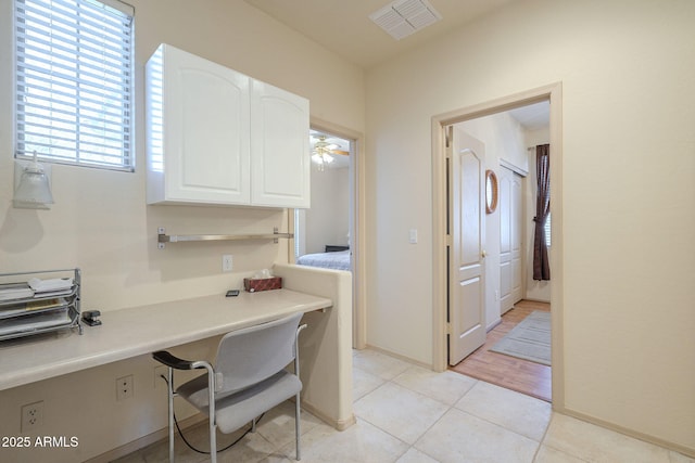 interior space featuring tile patterned flooring, visible vents, and baseboards