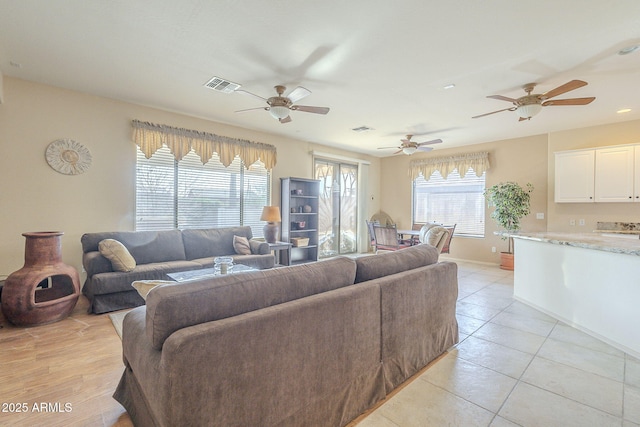 living area featuring a healthy amount of sunlight, visible vents, and baseboards