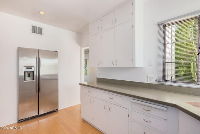 kitchen featuring white cabinetry, light hardwood / wood-style flooring, and stainless steel refrigerator with ice dispenser