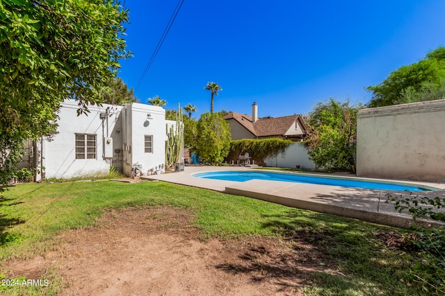 view of swimming pool featuring a yard