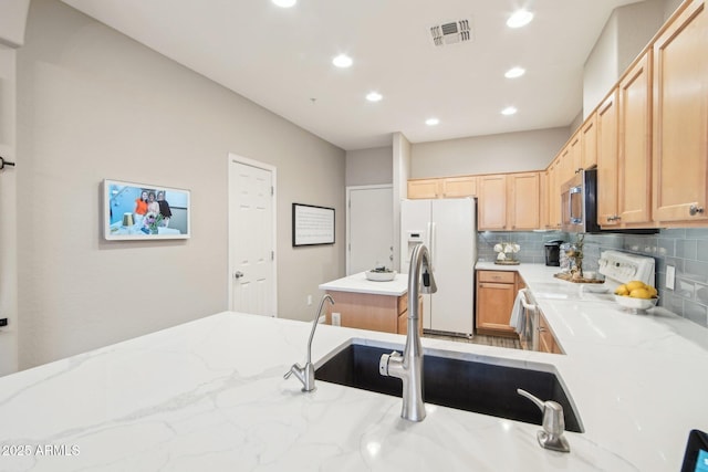 kitchen featuring white fridge with ice dispenser, electric range, visible vents, and tasteful backsplash