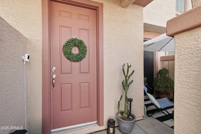 entrance to property featuring stucco siding