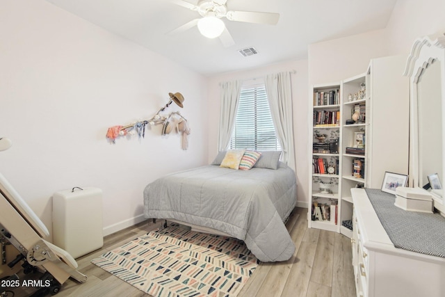 bedroom featuring a ceiling fan, light wood-style flooring, visible vents, and baseboards