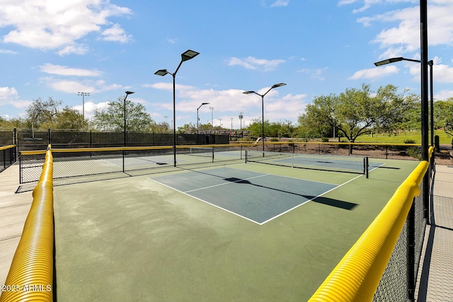 view of tennis court featuring fence