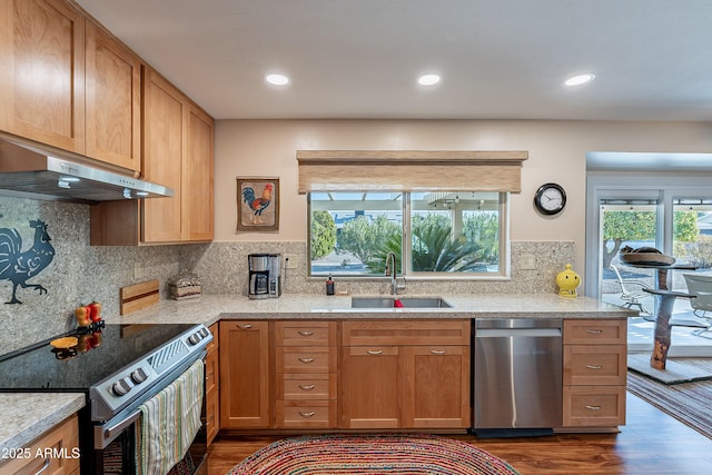 kitchen with appliances with stainless steel finishes, sink, backsplash, light stone counters, and dark wood-type flooring