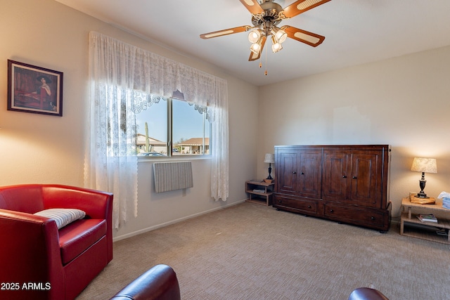 living area featuring light carpet and ceiling fan