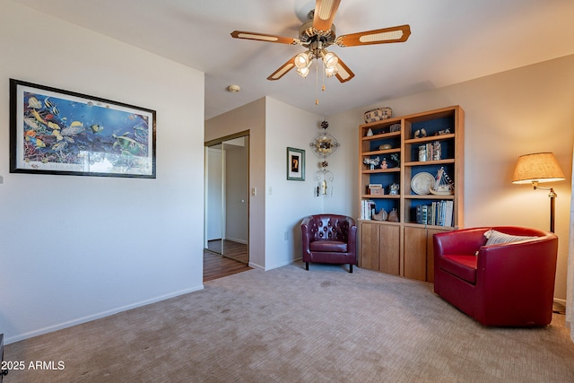 sitting room featuring light carpet and ceiling fan